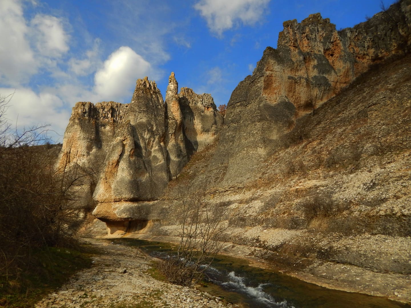 Weathered limestone walls above the bed of the Rachene at Kameno Pole